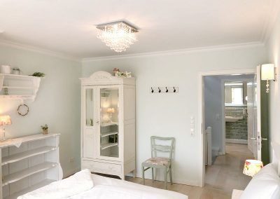 Schlafzimmer mit weißen Möbeln im Shabby Chic